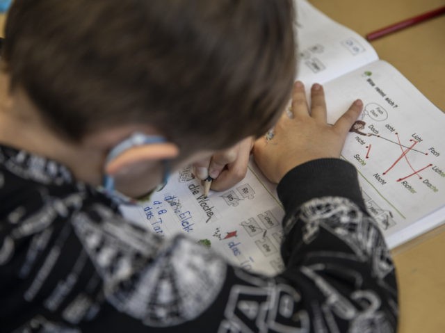 BERLIN, GERMANY - FEBRUARY 09: Boy, who has been granted an exception to come in-person to school because of extenuating circumstances, writes in his note book at the GutsMuths elementary school during the coronavirus pandemic on February 9, 2021 in Berlin, Germany. Schools across Germany are currently closed for in-person …