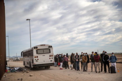 YUMA, ARIZONA - DECEMBER 07: A bus filled with immigrants departs as remaining migrants fr