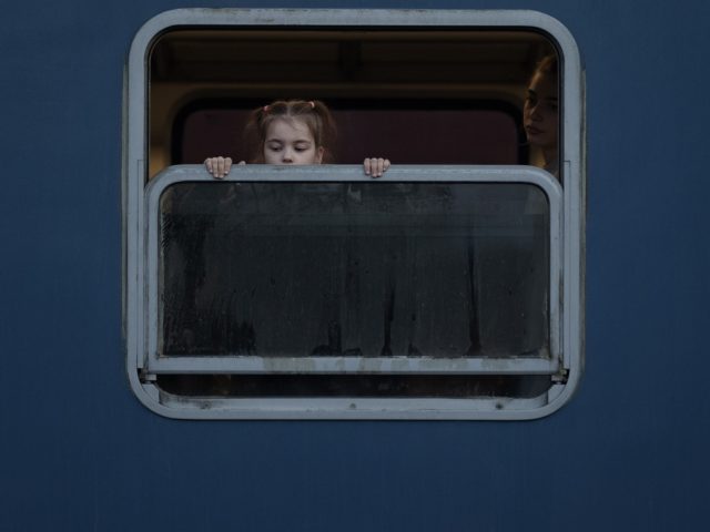 ZAHONY, HUNGARY - MARCH 17: Refugee children fleeing Ukraine look oput the window as they