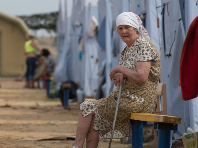 A refugee from eastern Ukraine looks on as she sits in a refugee camp near the Russian cit