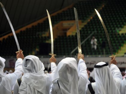 Saudi traditional dance team perform with swords during the traditional Saudi dancing best known as 'Arda' during the Janadriya culture festival at Der'iya in Riyadh, on February 18, 2014. The Prince of Wales arrived in Saudi Arabia in a private visit. AFP PHOTO/POOL/FAYEZ NURELDINE (Photo credit should read FAYEZ NURELDINE/AFP …