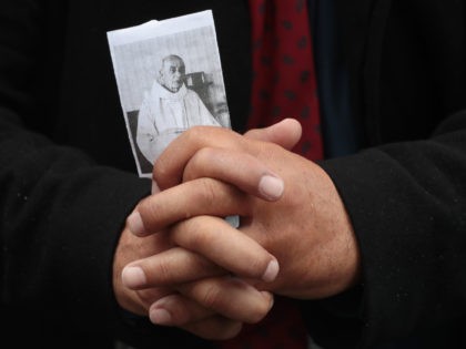 A person holds a picture of the priest Jacques Hamel outside Rouen's cathedral on August 2