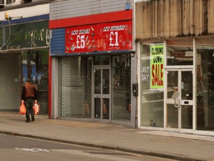 LONDON, ENGLAND - MARCH 13: A shopper walks past row of shops on Kilburn High Road on March 13, 2009 in London, England. The UK recession is seeing an increasing number of high street store closures, with many well established brands unable to survive the downturn. (Photo by Oli Scarff/Getty …