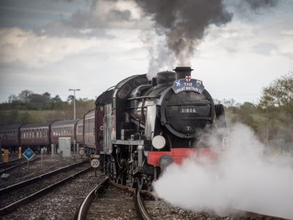 YEOVIL, ENGLAND - APRIL 26: A historic 1920s 'Mogul' steam locomotive is coupled to a ten-carriage train, leaves Yeovil Junction near Yeovil on April 26, 2018 in Somerset, England. The Southern Railway 1920s 'Mogul' steam locomotive will haul the special excursion main line passenger train between Yeovil, Dorchester and Weymouth …