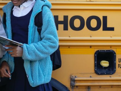 Girl in front of school bus