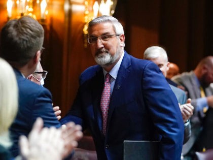 Indiana Gov. Eric Holcomb talks with representatives after he delivered his State of the State address to a joint session of the legislature at the Statehouse, Tuesday, Jan. 11, 2022, in Indianapolis. (AP Photo/Darron Cummings)