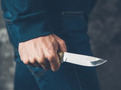 Man hand holding knife on abstract background