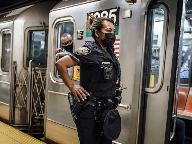 FILE - A New York City Police Department officer and a subway conductor look down the subw