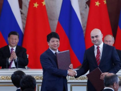 Chinese President Xi Jinping (L) and Russian President Vladimir Putin (R) applaud as Guo Ping (2L), Deputy Chairman of the Board and Rotating Chairman of Huawei, shakes hands with Alexei Kornya (2R), President and CEO of Russian mobile phone operator MTS, during a signing ceremony following Russian-Chinese talks at the …