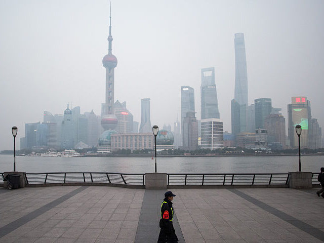 A security guard walks at the bund near the Huangpu river across the Pudong New Financial