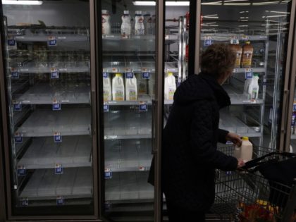 SPRINGFIELD, VIRGINIA - JANUARY 12: A woman takes a jug of milk off of depleted refrigerat