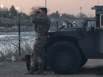 A Texas National Guard soldier monitors the Mexican side of the Rio Grande to help deter illegal border crossings. (Bob Price/Breitbart Texas)