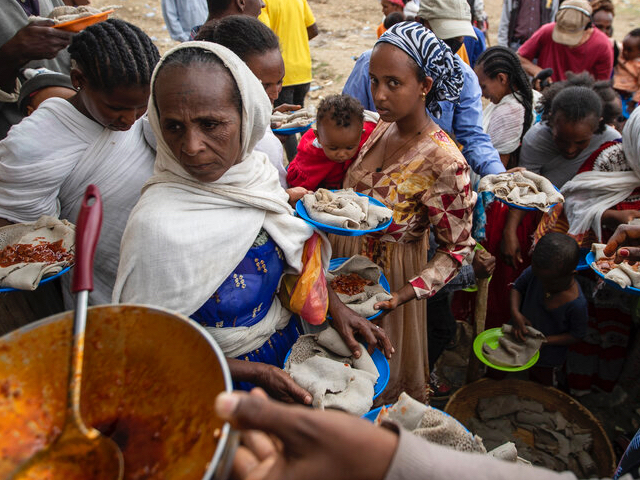 Displaced Tigrayans queue to receive food donated by local residents at a reception center for the internally displaced in Mekele, in the Tigray region of northern Ethiopia on May 9, 2021. The Ethiopian government on Thursday, March 24, 2022 announced what it called an "indefinite humanitarian truce" in its war-ravaged Tigray region, saying the action was necessary to allow unimpeded relief supplies into the area. (AP Photo/Ben Curtis, File)