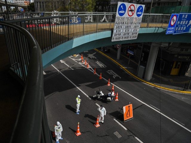 CHINA-HEALTH-VIRUS Transit officers, wearing protective gear, control access to a tunnel in the direction of Pudong district in lockdown as a measure against the Covid-19 coronavirus, in Shanghai on March 28, 2022. - Millions of people in China's financial hub were confined to their homes on March 28 as the …