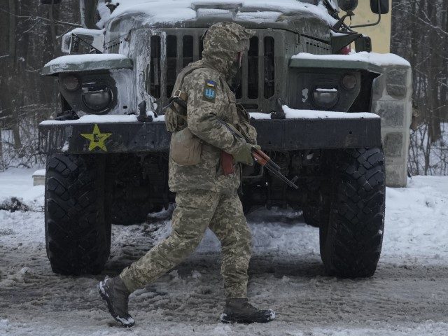 A Ukrainian serviceman walks by a deactivated Russian military multiple rocket launcher on
