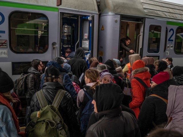 Ukrainian evacuees board a train en route to Warsaw at the rail station in Przemysl, near the Polish-Ukrainian border, on March 26, 2022.