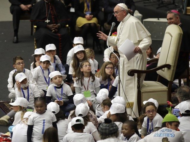 FILE - In this Thursday, Dec. 15, 2016 file photo, Pope Francis is surrounded by children