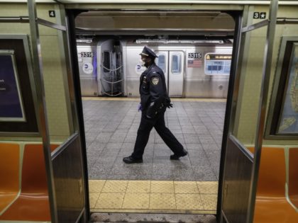 NYPD officers wake up sleeping passengers and direct them to the exits at the 207th Street A-train station, Thursday, April 30, 2020, in the Manhattan borough of New York.