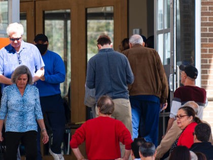 Voters exit after participating in the primary election as others wait in line at Our Redeemer Lutheran Church in Dallas, Texas on Tuesday, March 1, 2022. (AP Photo/Emil Lippe)