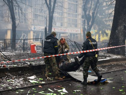 EDITORS NOTE: Graphic content / TOPSHOT - Police officers remove the body of a passerby ki