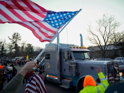 HAGERSTOWN, MARYLAND - MARCH 4: Supporters cheer as they greet the Peoples Convoy of truckers as it arrives at the Hagerstown Speedway on March 4, 2022 in Hagerstown, Maryland. The convoy, modeled after the Canadian trucker protests, is one of several on the way to the nation's capital region in …