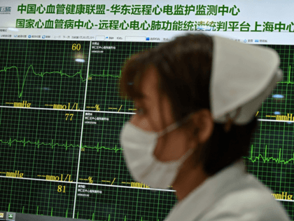 A nurse walks in an area where doctors take video calls from patients suffering various symptoms and illnesses, to avoid crowding at Xuhui District Hospital in Shanghai on March 9, 2020. - China reported 22 new deaths on March 9 from the new coronavirus epidemic, and the lowest number of …