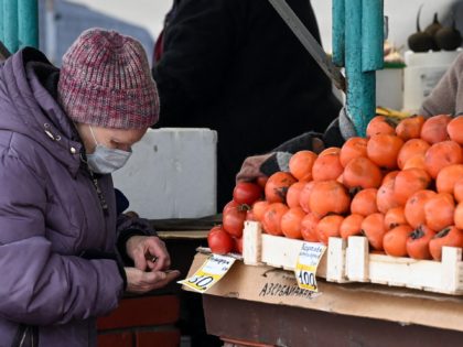 A woman buys fruits at a market in Moscow on December 15, 2021. (Photo by Kirill KUDRYAVTS
