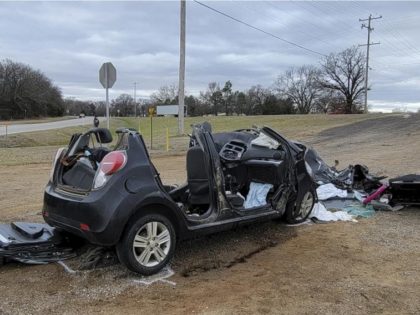 In this image provided by KFOR-TV, a heavily damaged vehicle is seen off a road in Tishomingo, Okla., following a two-vehicle collision in which six teenage students were killed, Tuesday, March 22, 2022. (NewsNation KFOR via AP)