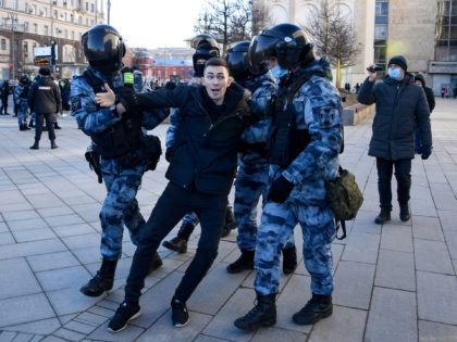 TOPSHOT - Police officers detain a man during a protest against Russia's invasion of Ukrai