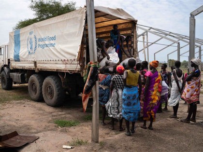 Women from Murle ethnic group unload bags of sorghum from a truck during a food distribution by United Nations World Food Programme (WFP) in Gumuruk, South Sudan, on June 10, 2021, as their village where recently attacked by armed youth group. - An escalation in conflict has led to the …