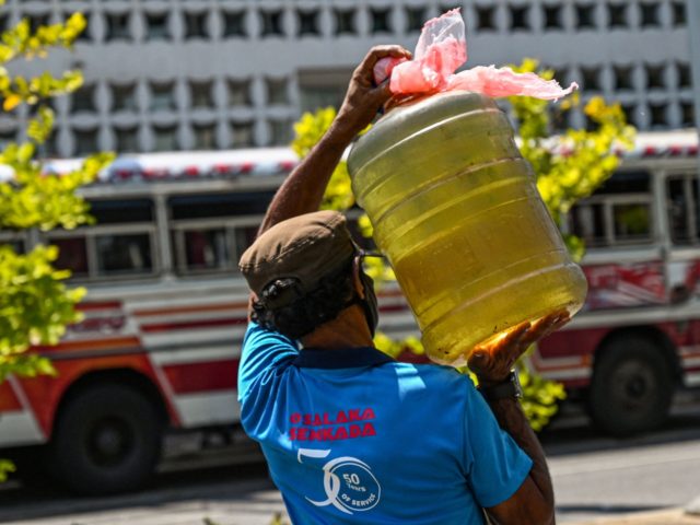 A man leaves carrying a container filled with diesel fuel, from a Ceylon Petroleum Corporation fuel station in Colombo on March 29, 2022. (Photo by Ishara S. KODIKARA / AFP) (Photo by ISHARA S. KODIKARA/AFP via Getty Images)