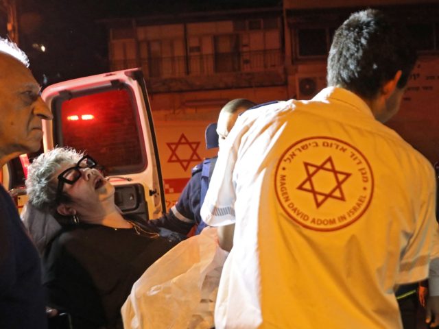 Israeli emergency personnel evacuate a wounded woman from the scene of a shooting attack o