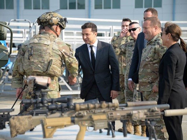 Volodymyr Zelenskyy, president of Ukraine, shakes hands with an Airman while receiving a d