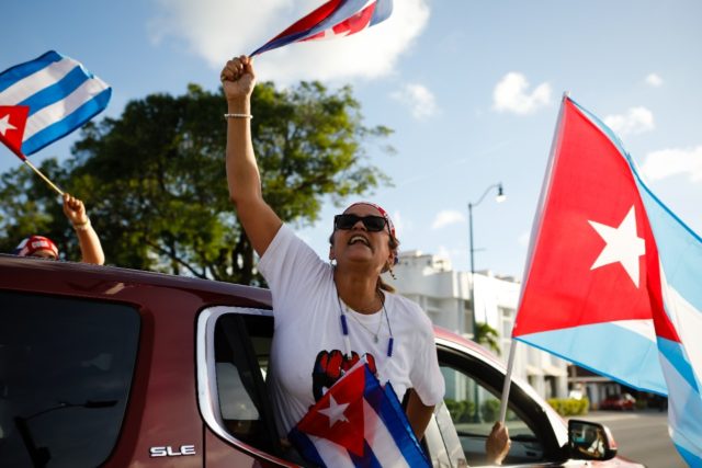 A woman holds a Cuban flag during a protest showing support for Cubans demonstrating again