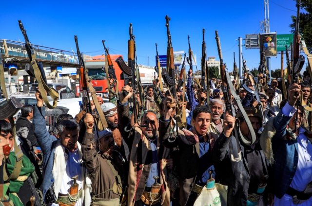 Armed Yemeni supporters of the Iran-backed Huthi movement, brandish their weapons as they