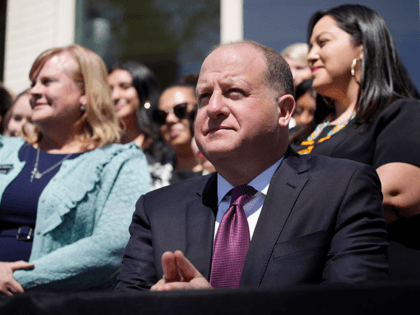 Colorado Governor Jared Polis waits to sign into law the reproductive health equity act during a ceremony outside the governor's mansion, Monday, April 4, 2022, in Denver. Two of the bill's sponsors, Sen. Julie Gonzalez, back right, and Rep. Meg Froelich, back left, look on with guests and other lawmakers …