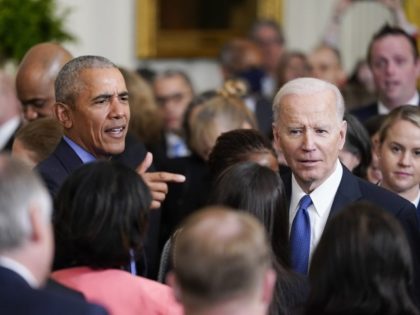 President Joe Biden and former President Barack Obama speak to people during an event marking the 12th anniversary of the Affordable Care Act in the East Room of the White House in Washington, Tuesday, April 5, 2022. (AP Photo/Carolyn Kaster)
