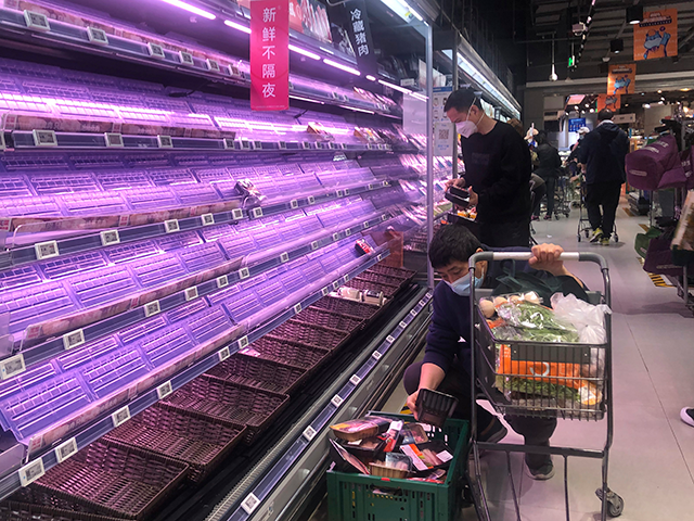 Customers look through empty shelves at a supermarket in Shanghai, China, on March 30, 202