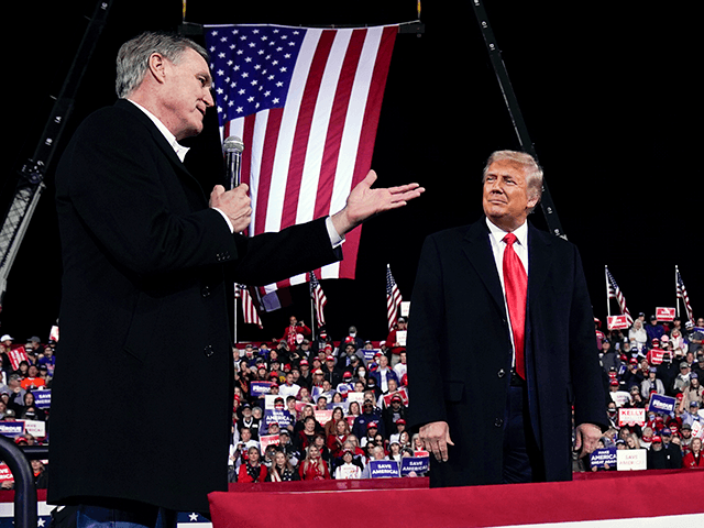 Former Sen. David Perdue of Georgia, speaks as President Donald Trump looks on, at a campa
