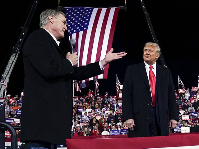 FILE - Former Sen. David Perdue of Georgia, speaks as President Donald Trump looks on, at a campaign rally at Valdosta Regional Airport, Dec. 5, 2020, in Valdosta, Ga. Perdue is building his campaign around Donald Trump and veering to the right as he tries to unseat Republican Gov. Brian Kemp in a May 24 GOP primary. (AP Photo/Evan Vucci, File)