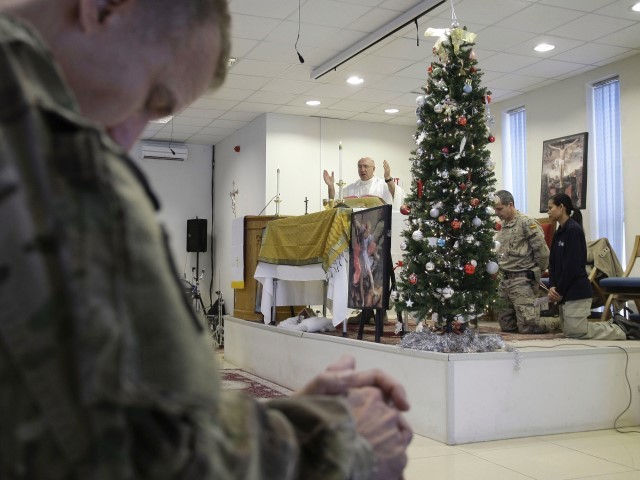 U.S. Army Chaplain Lt. Col. George Rzasowsk, center, leads a Christmas service for soldiers and service members with the NATO- led International Security Assistance Force (ISAF) at the U.S.-led coalition base in Kabul, Afghanistan, Tuesday, Dec. 25, 2012. 
