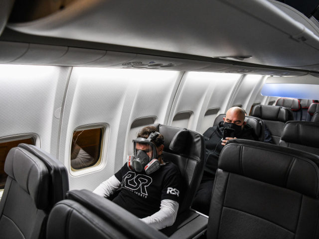 A man wears a gasmask as he travels in a flight from Miami to Atlanta in Miami, on April 2
