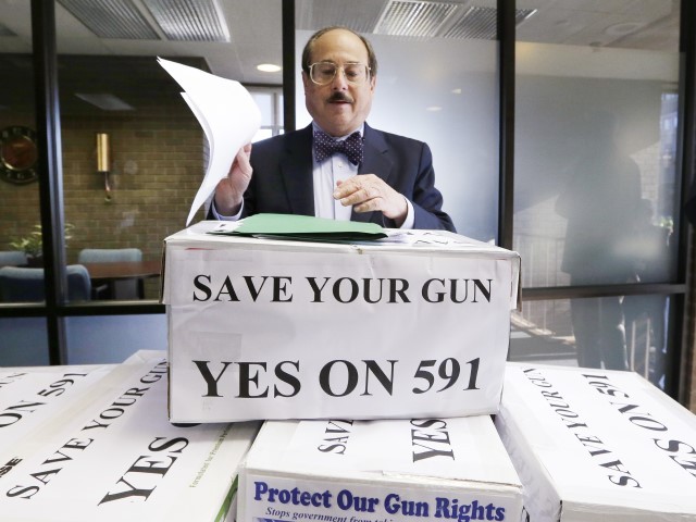 Alan Gottlieb, chairman of the Citizens Committee for the Right to Keep and Bear Arms prepares to read a statement as he stands with the first batch of signatures for a gun rights initiative that would prevent Washington state from adopting universal background checks for gun sales, in Olympia, Wash.