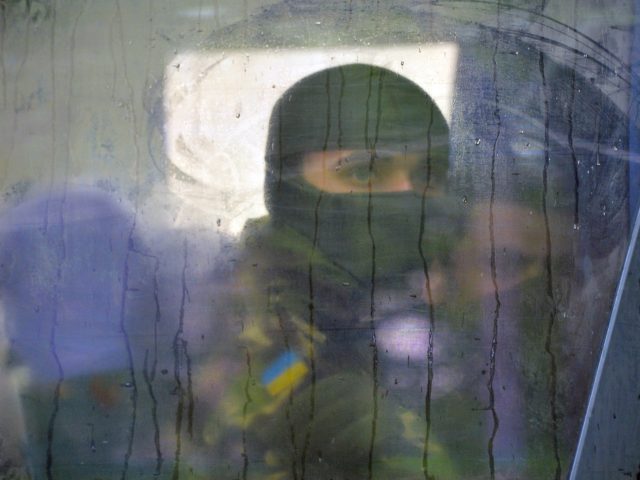 A volunteer of the Ukrainian Azov regiment looks through a bus window before a departure t