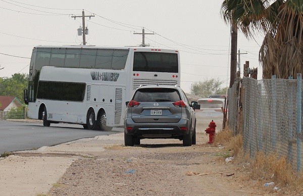 A double-decker charter bus departs from the Mission Border Hope shelter in Eagle Pass carrying up to 80 migrants to San Antonio. (A migrant woman discards trash after illegally crossing the border near Eagle Pass, Texas, on the eve of Easter. (Randy Clark/Breitbart Texas)
