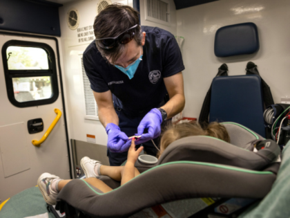 An EMS medic from the Houston Fire Department prepares to transport a Covid-19 positive girl, age 2, to a hospital on August 25, 2021 in Houston, Texas. The child's mother said she had come down with fever, runny nose and had begun vomiting after attending a day care center the …