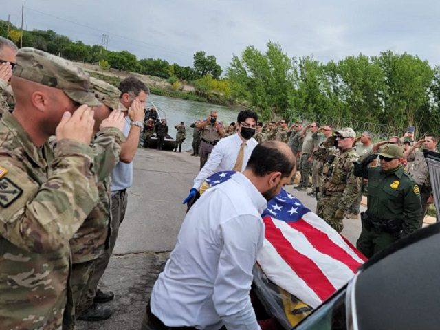 The flag-draped body of Texas National Guardsman Bishop E. Evans is placed in a hearse wit