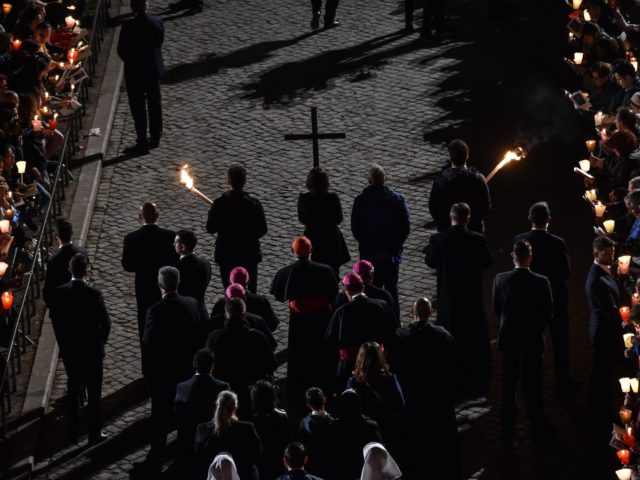Worshipers carrying a cross march towards the Pope (not pictured) during the Via Crucis (W