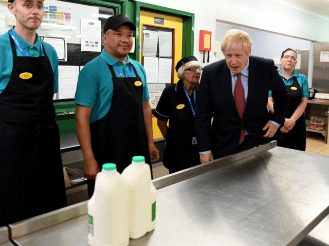 British Prime Minister Boris Johnson (R) speaks to kitchen staff as he visits Torbay Hospi