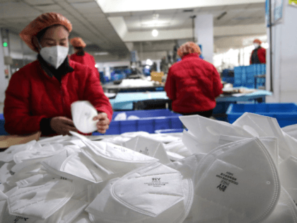 This photo taken on January 22, 2020 shows workers producing facemasks at a factory in Han